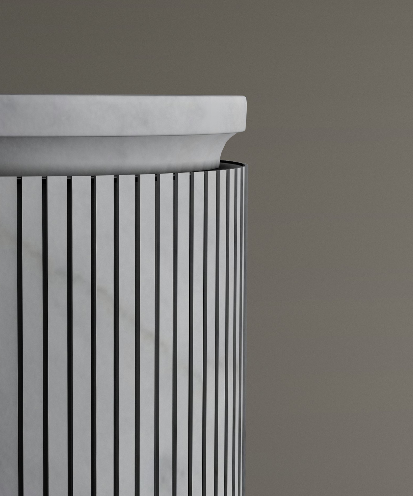 A close-up of the TRAVERTABLE Carrara Round Marble Pedestal Vanity Sink shows its cylindrical form with vertical black lines, set against a plain brownish-grey background, highlighting Italian bathroom elegance.