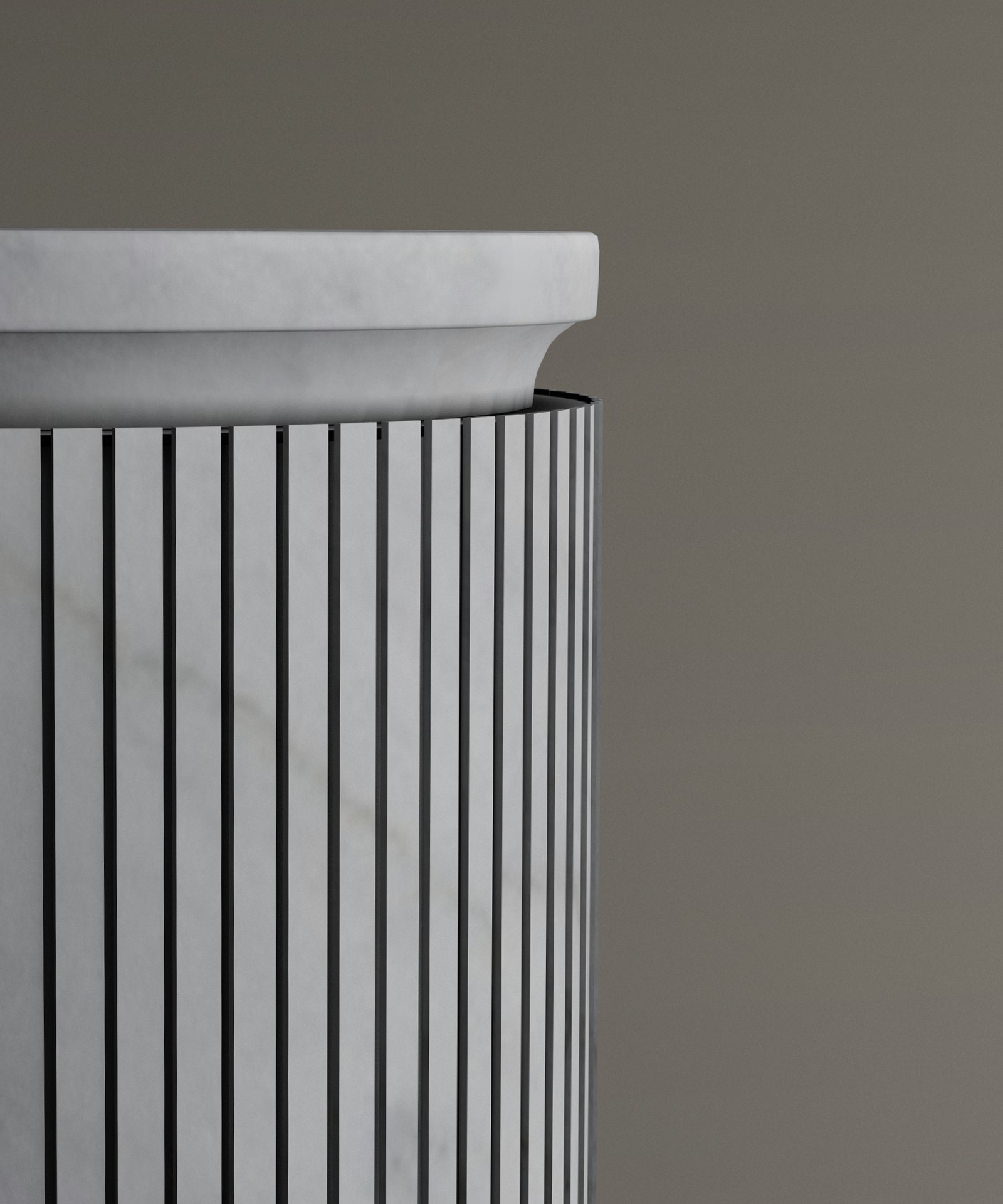 A close-up of the TRAVERTABLE Carrara Round Marble Pedestal Vanity Sink shows its cylindrical form with vertical black lines, set against a plain brownish-grey background, highlighting Italian bathroom elegance.